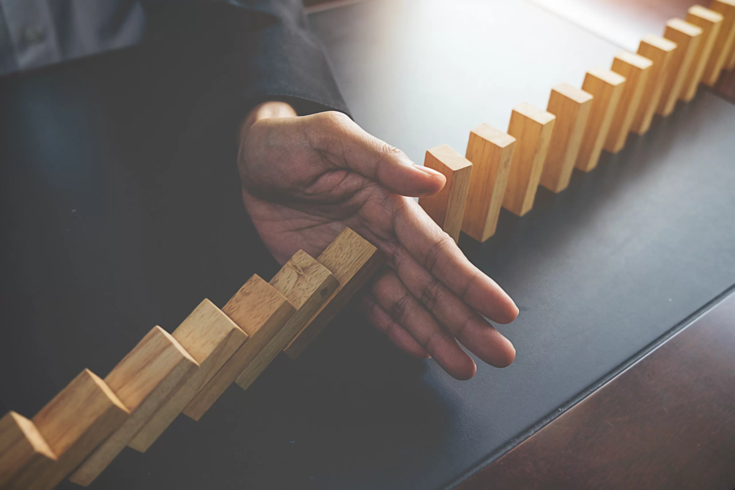 problem-solving-close-up-view-hand-business-woman-stopping-falling-blocks-table-concept-about-taking-responsibility